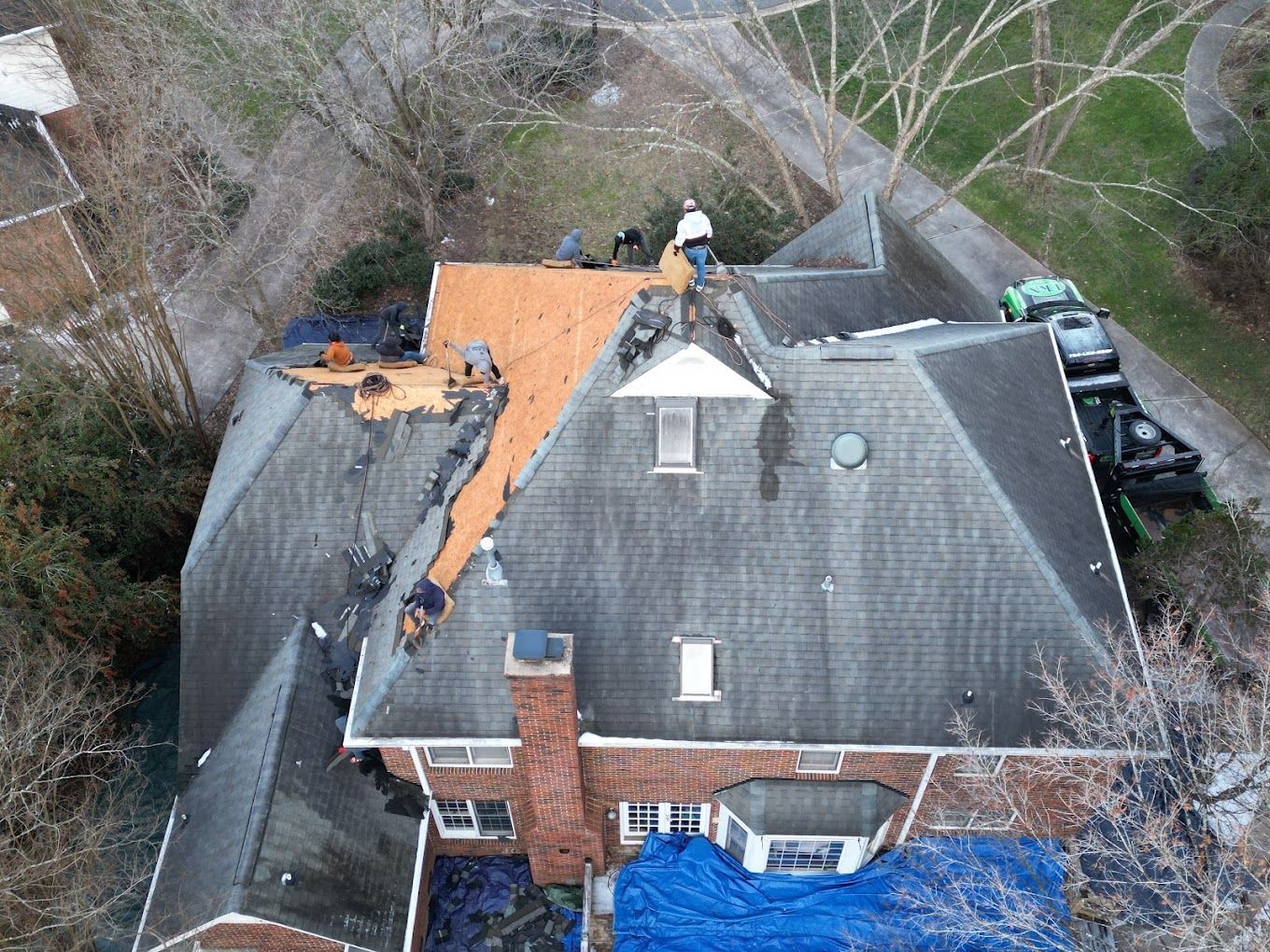 An aerial view of a house with a roof being repaired.