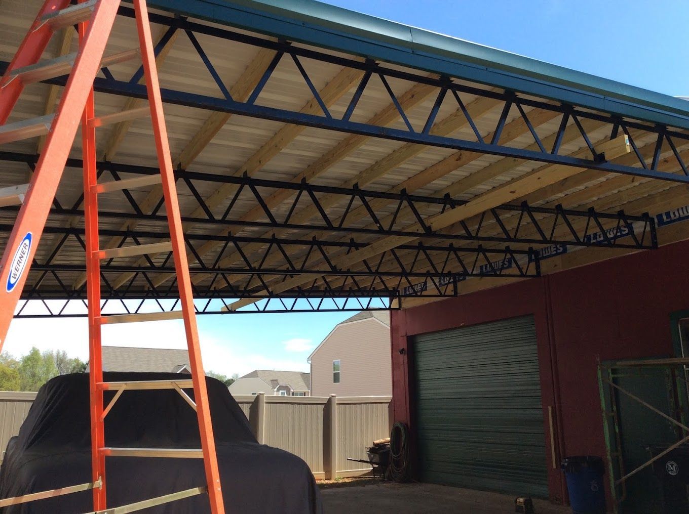 A ladder is sitting under a roof that is being built