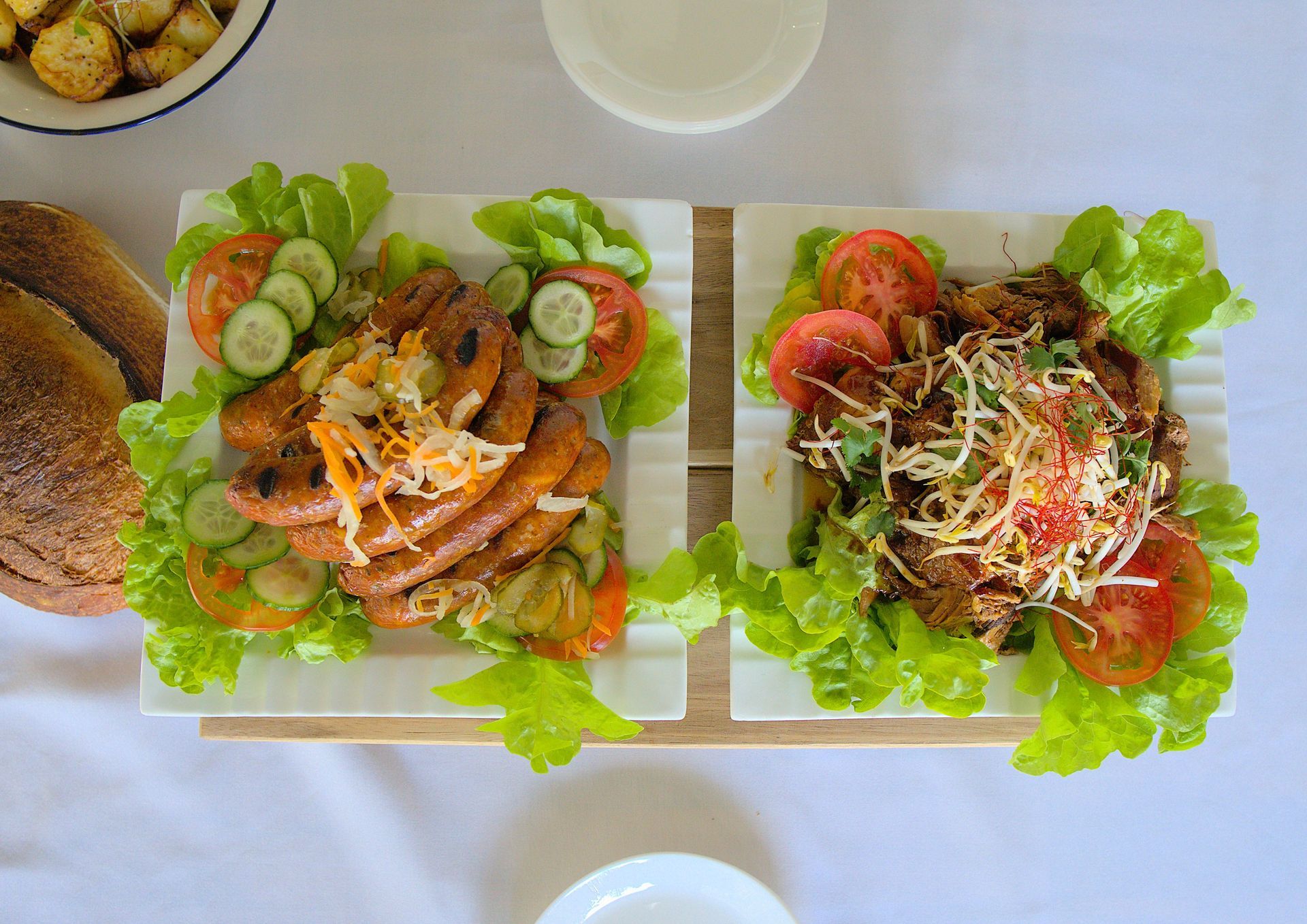 Two Platters of Food: Grilled Sausages and a Shredded Meat Dish — Lazy Paul's Cafe 'n Smokehouse In Wauchope, NSW