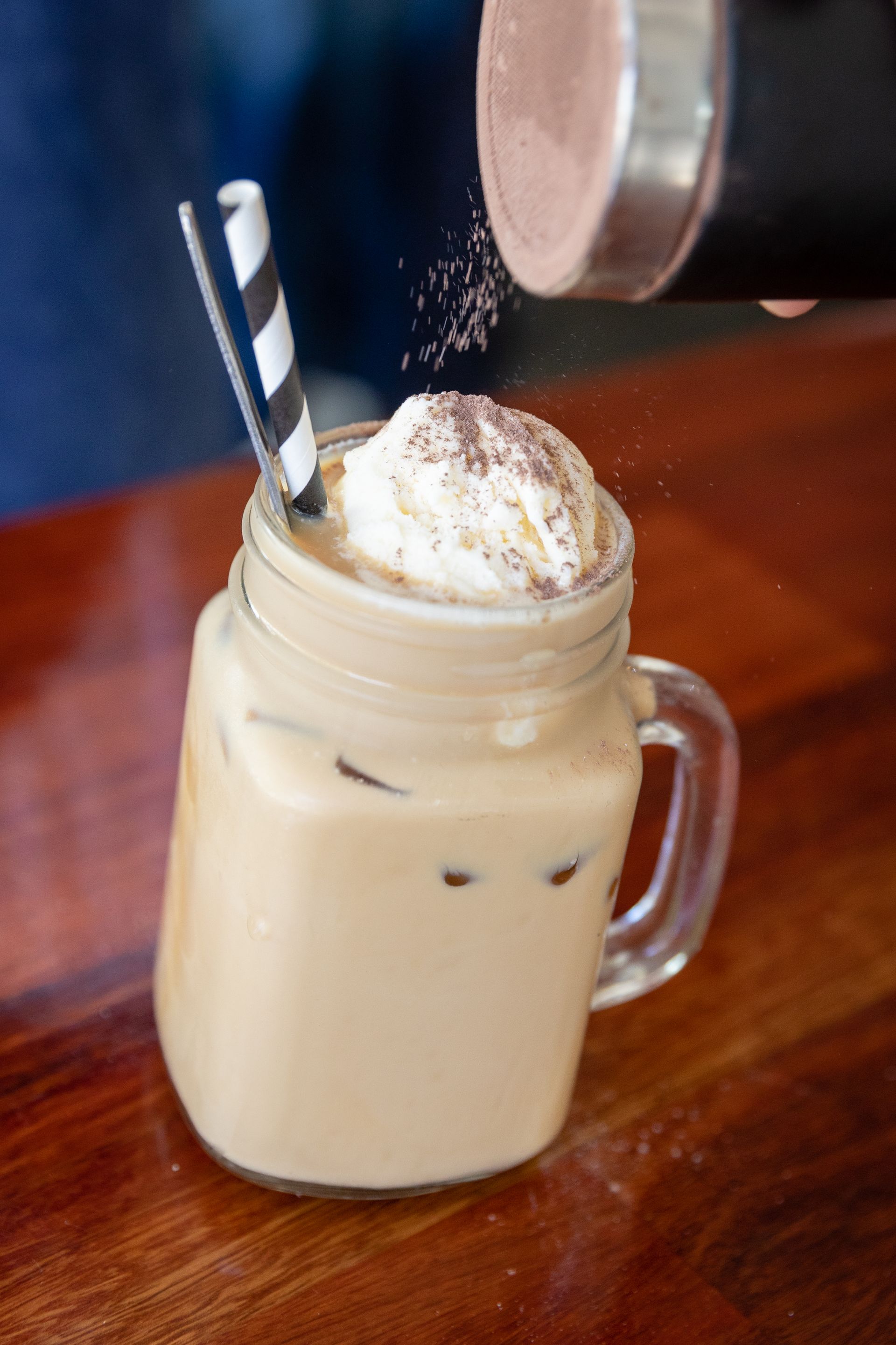 Iced Coffee in a Mason Jar With Whipped Cream Being Dusted — Lazy Paul's Cafe 'n Smokehouse In Wauchope, NSW