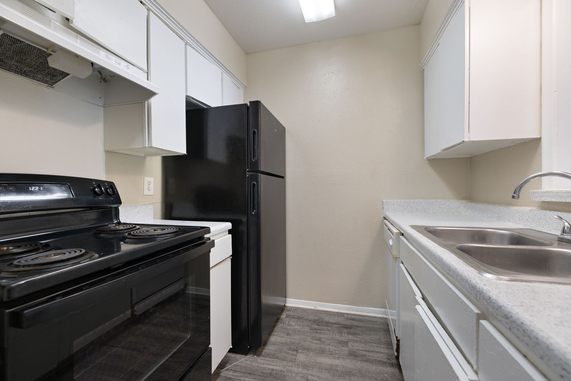 Kitchen island with black appliances, and white cabinetry 