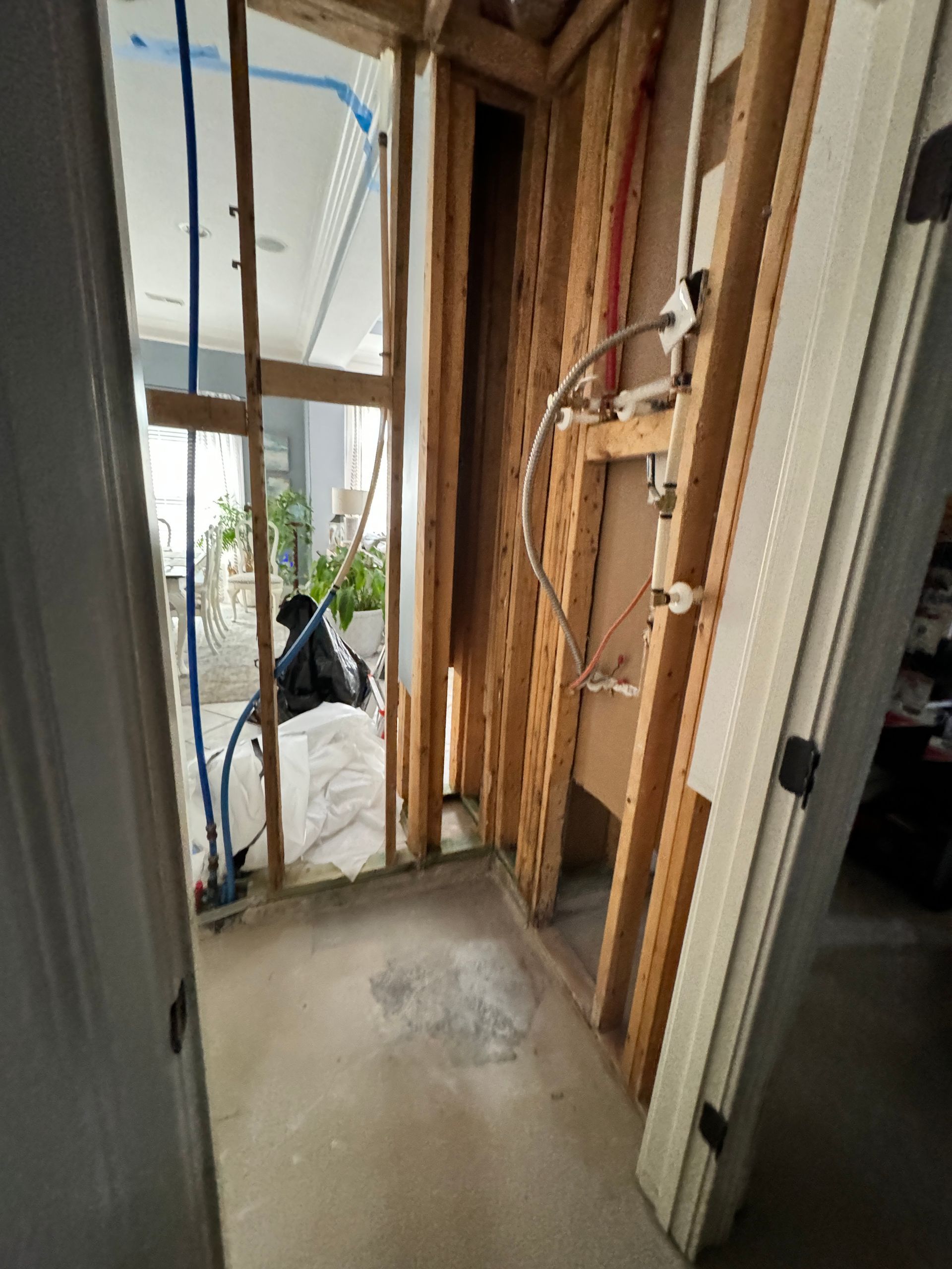 A kitchen with a stainless steel refrigerator and a trash can.