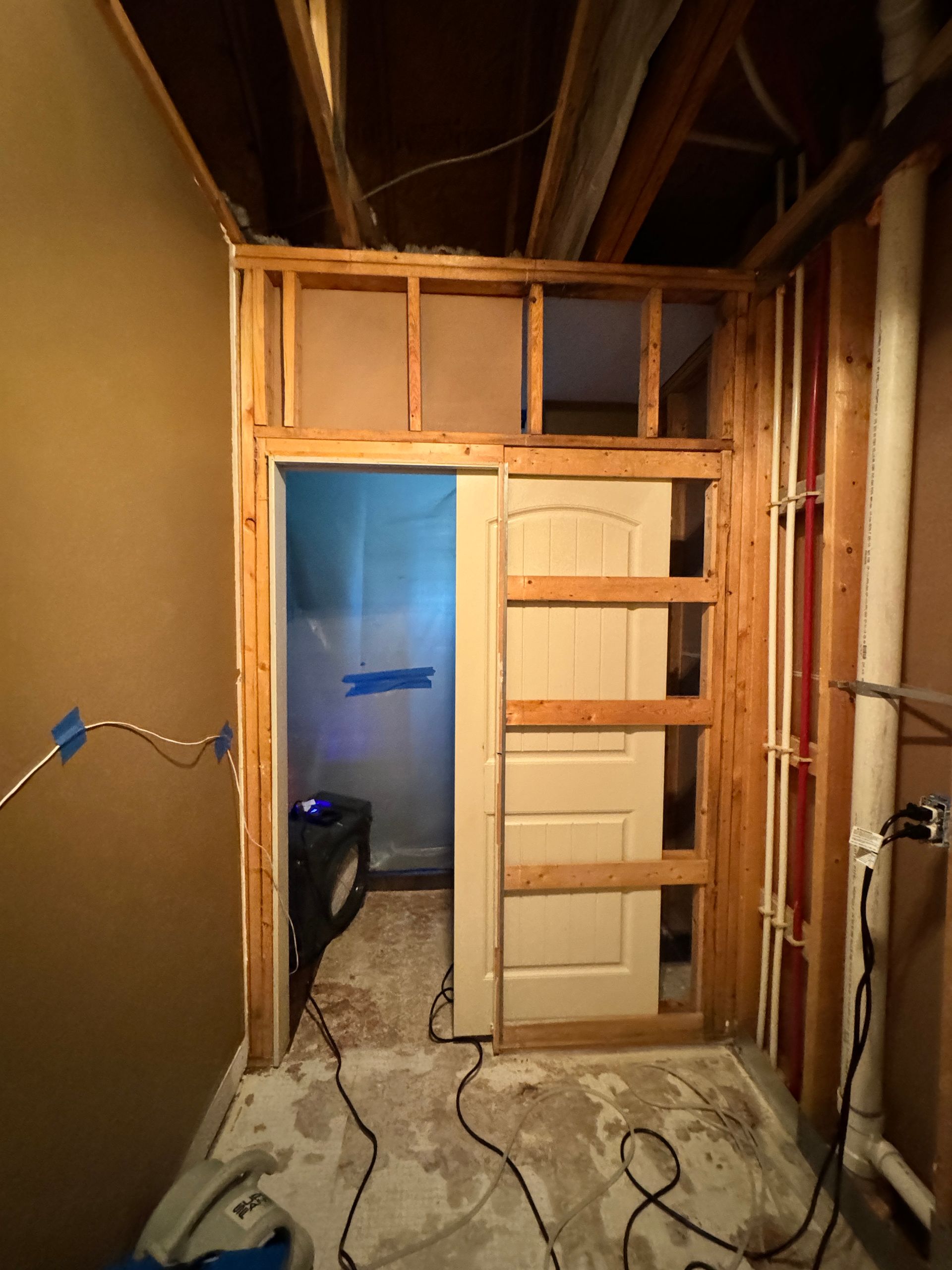 A living room with a couch and a door that is being remodeled.