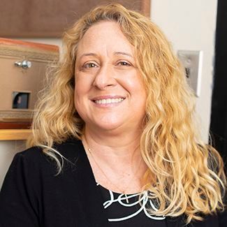 A woman with blonde curly hair is smiling for the camera.