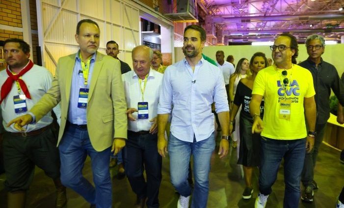 Um grupo de homens caminha juntos em uma sala.