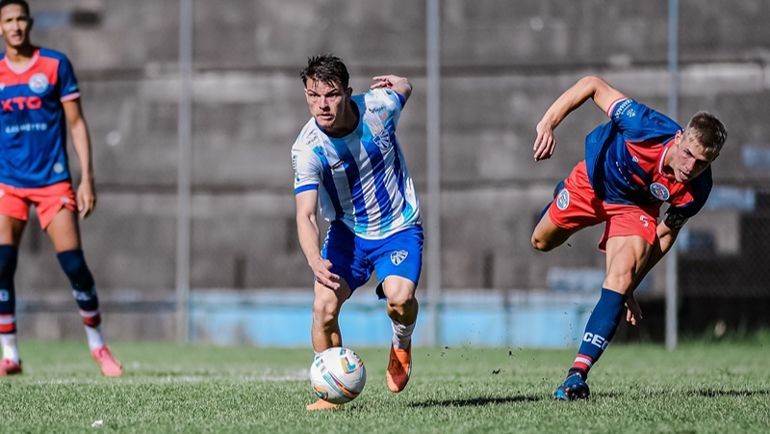 Um grupo de jogadores de futebol está jogando futebol em um campo.