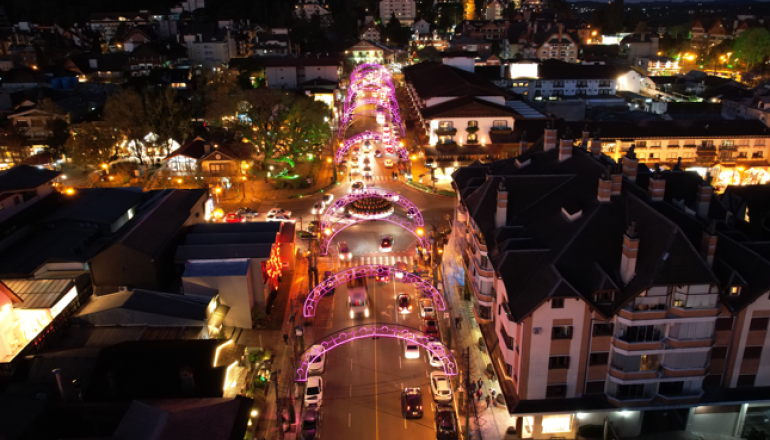 Uma vista aérea de uma cidade à noite com uma árvore de natal no meio da rua.