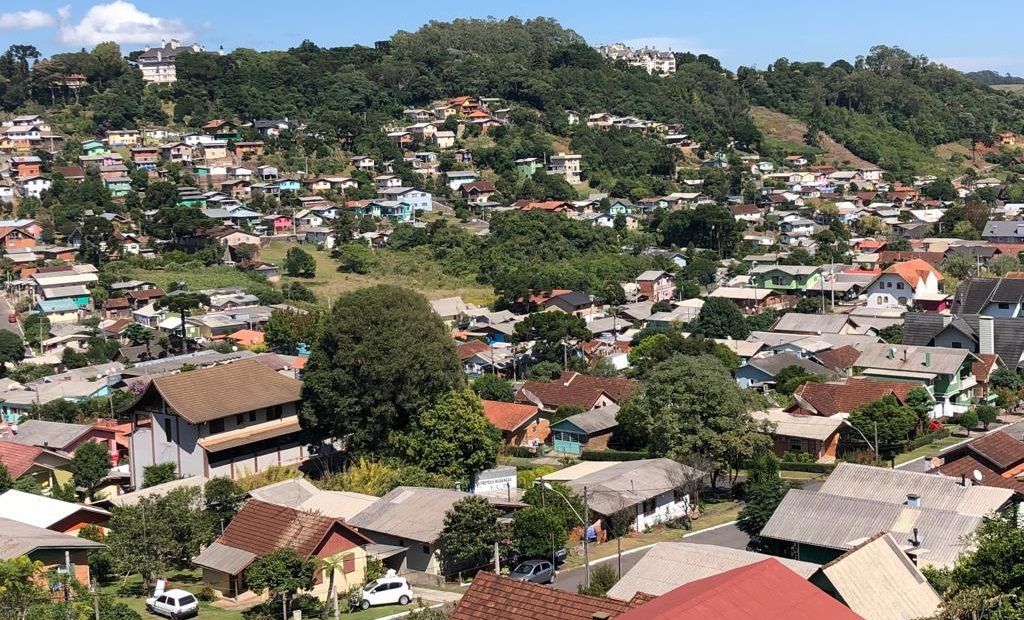 Uma vista aérea de uma área residencial com muitas casas em uma encosta.