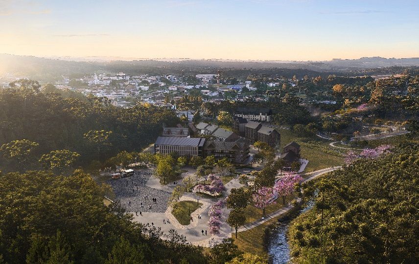 Uma vista aérea de uma cidade cercada por árvores e um rio.