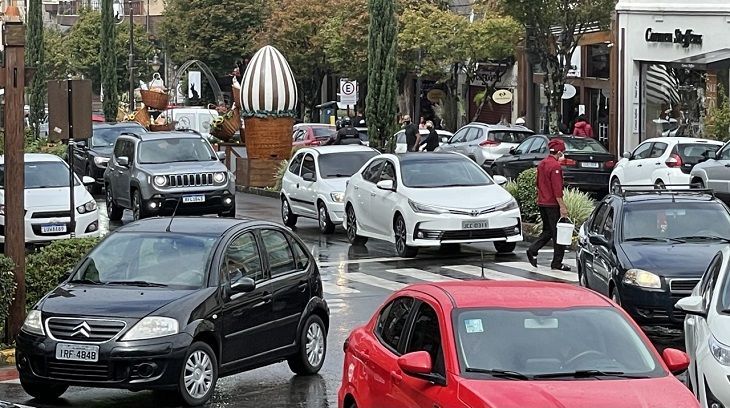 Muitos carros estão passando pela rua na chuva.
