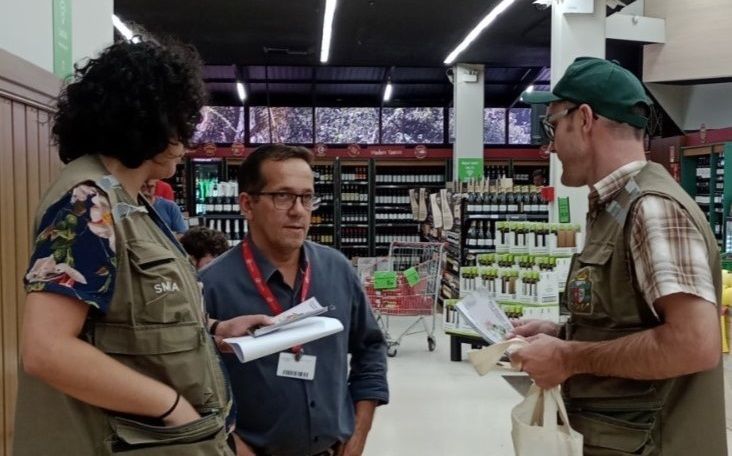 Um grupo de pessoas está em uma loja conversando entre si.