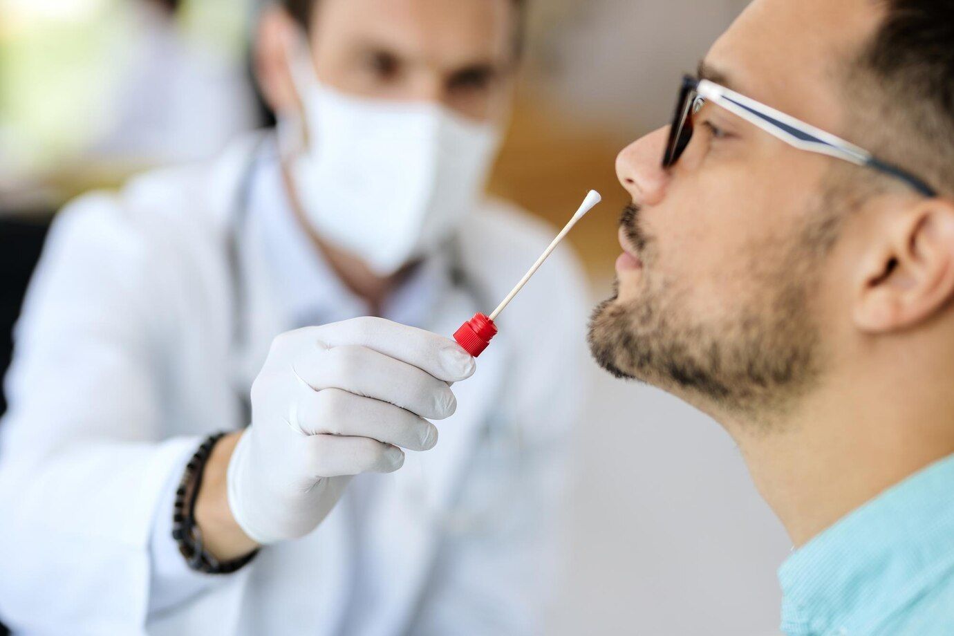 Um homem está recebendo um esfregaço nasal de um médico.