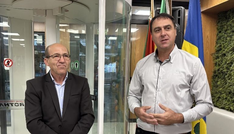 Dois homens estão parados um ao lado do outro em frente a uma porta de vidro.