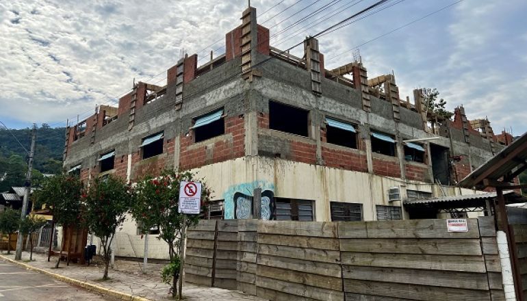 Um prédio em construção com uma cerca de madeira na frente.