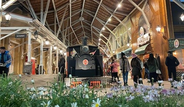 Um grupo de pessoas caminha em torno de uma estação de trem.