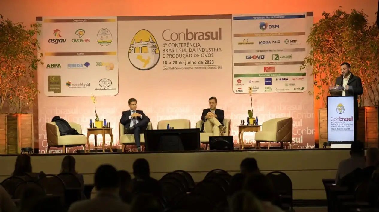 Um homem está discursando em uma conferência chamada contrasul
