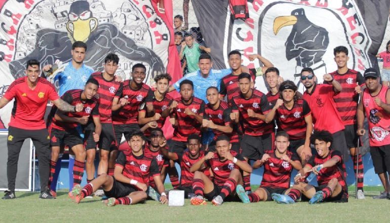 Um grupo de jogadores de futebol posa para uma foto no campo.