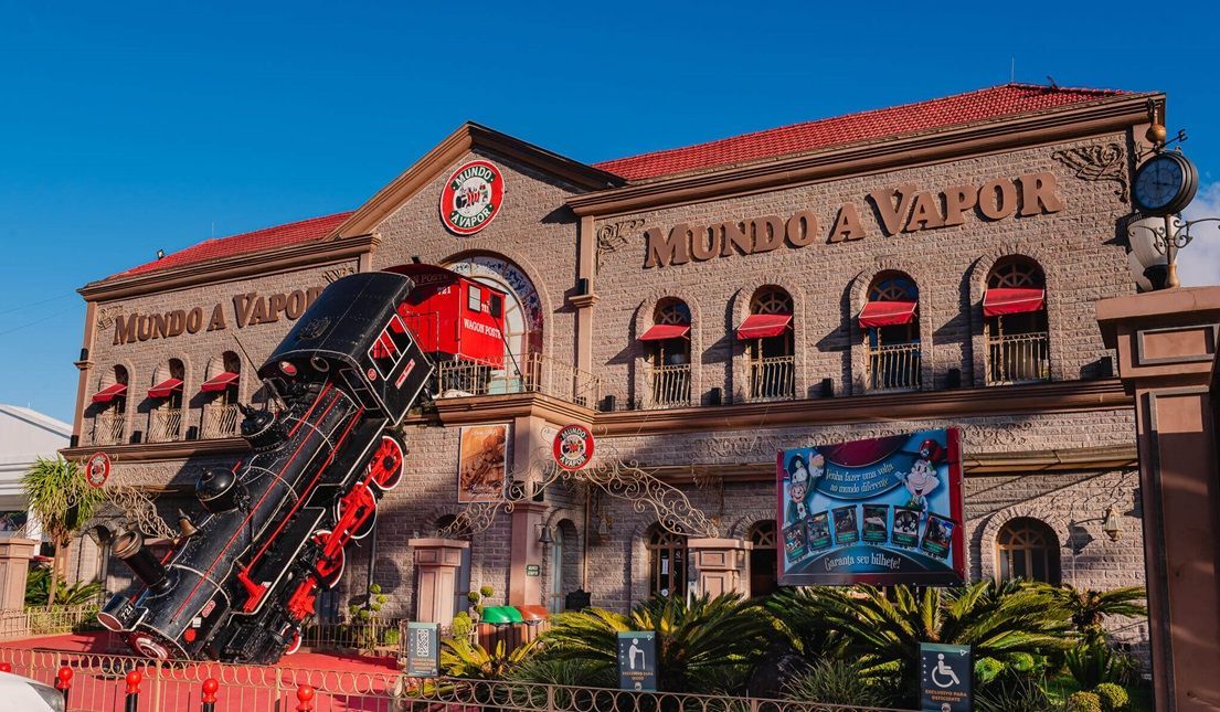 Um modelo de trem está parado em frente a um prédio.