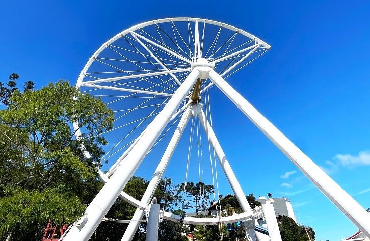 Uma grande roda gigante branca com um céu azul ao fundo