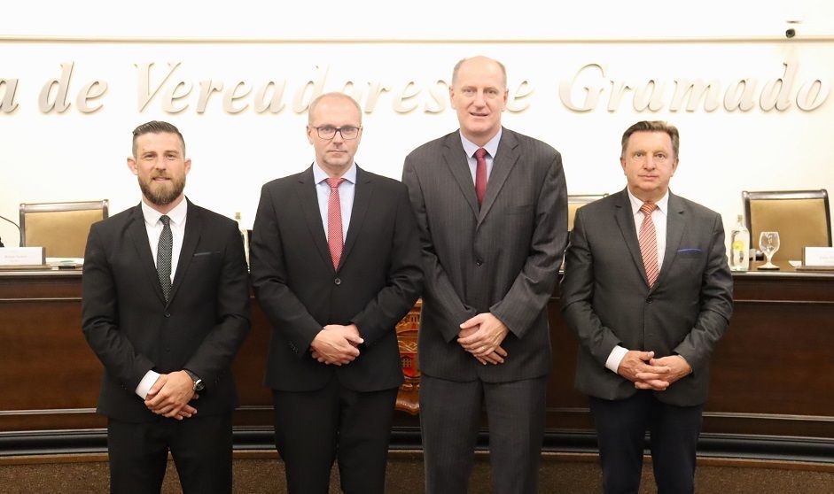 Um grupo de homens de terno e gravata posa para uma foto.