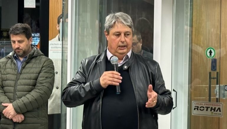 Um homem com uma jaqueta de couro está diante de um microfone.