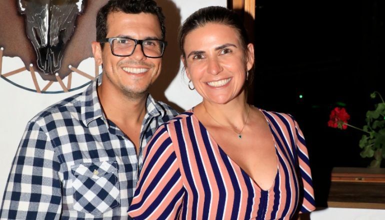 Um homem e uma mulher posam para uma foto em frente a uma caveira.