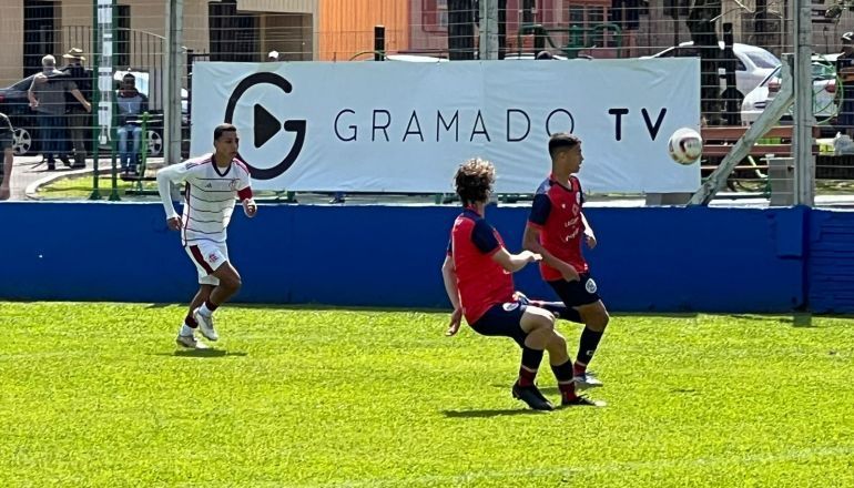 Um grupo de jovens está jogando futebol em um campo.