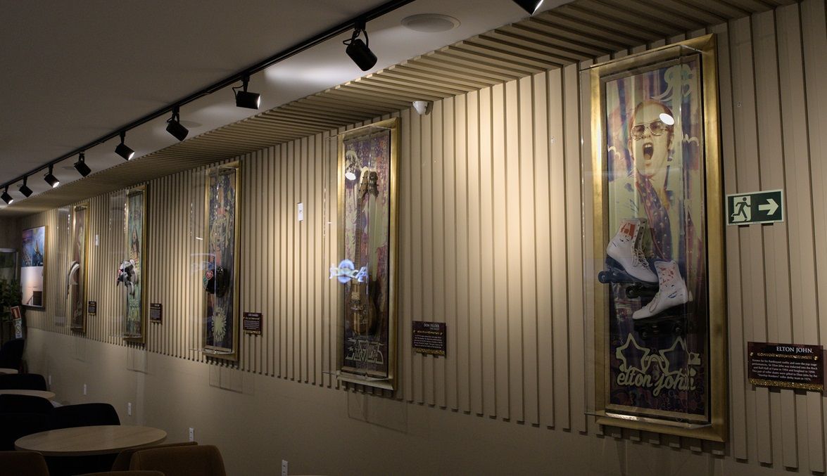 Uma fileira de pinturas está pendurada na parede de uma sala.
