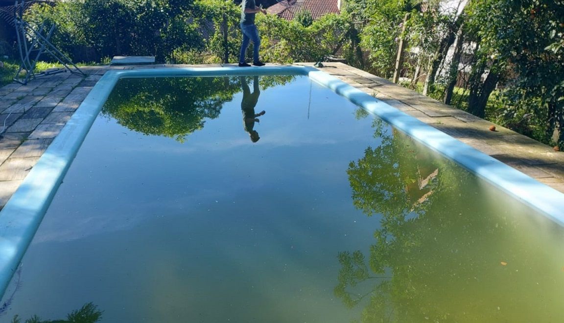 Um homem está parado na beira de uma piscina.