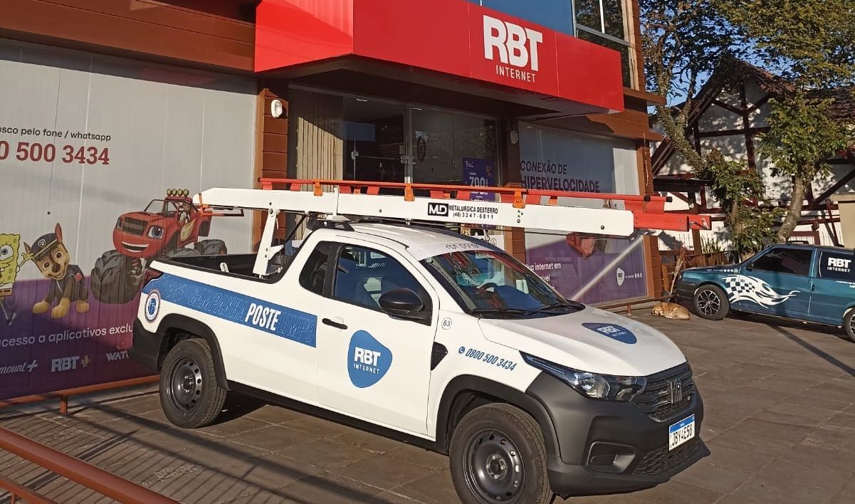 Um caminhão branco está estacionado em frente a um prédio.