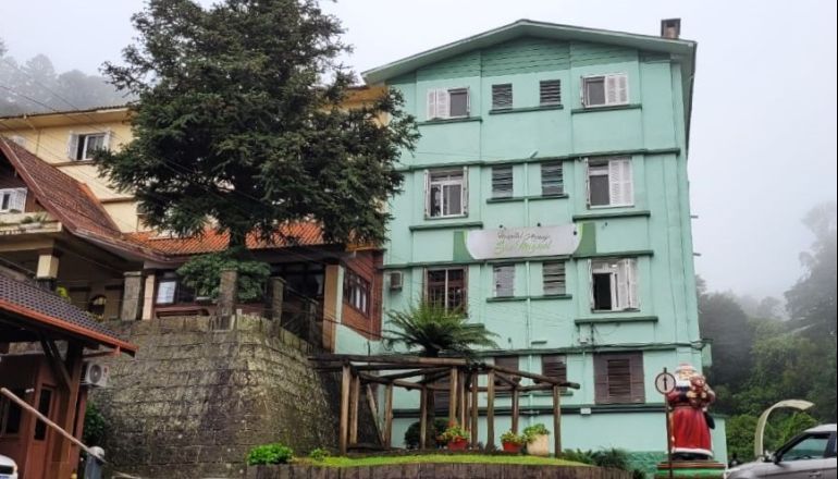 Um prédio verde com uma estátua de Papai Noel na frente