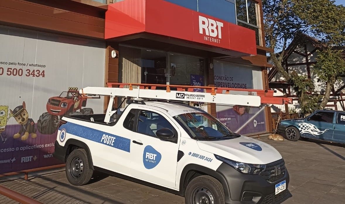 Um caminhão branco está estacionado em frente a um prédio.