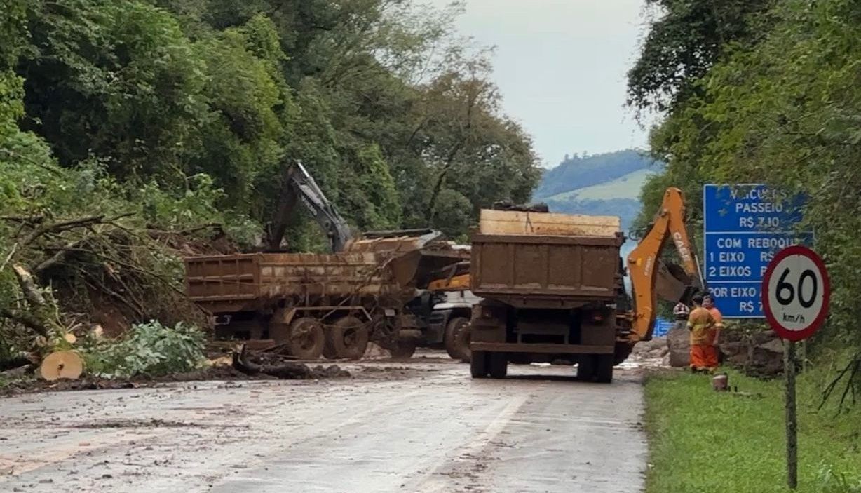 Um caminhão está dirigindo por uma estrada de terra próximo a uma placa que diz 60.