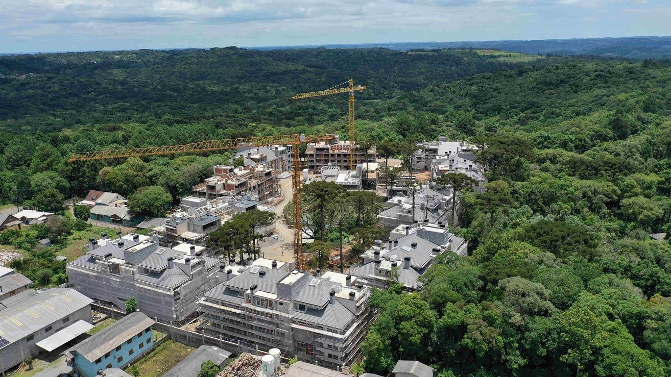 Uma vista aérea de um prédio em construção no meio de uma floresta.