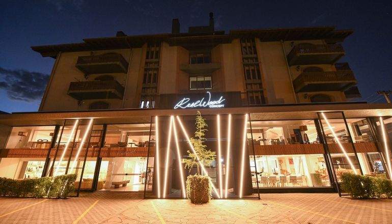 Um grande edifício com muitas janelas fica iluminado à noite.