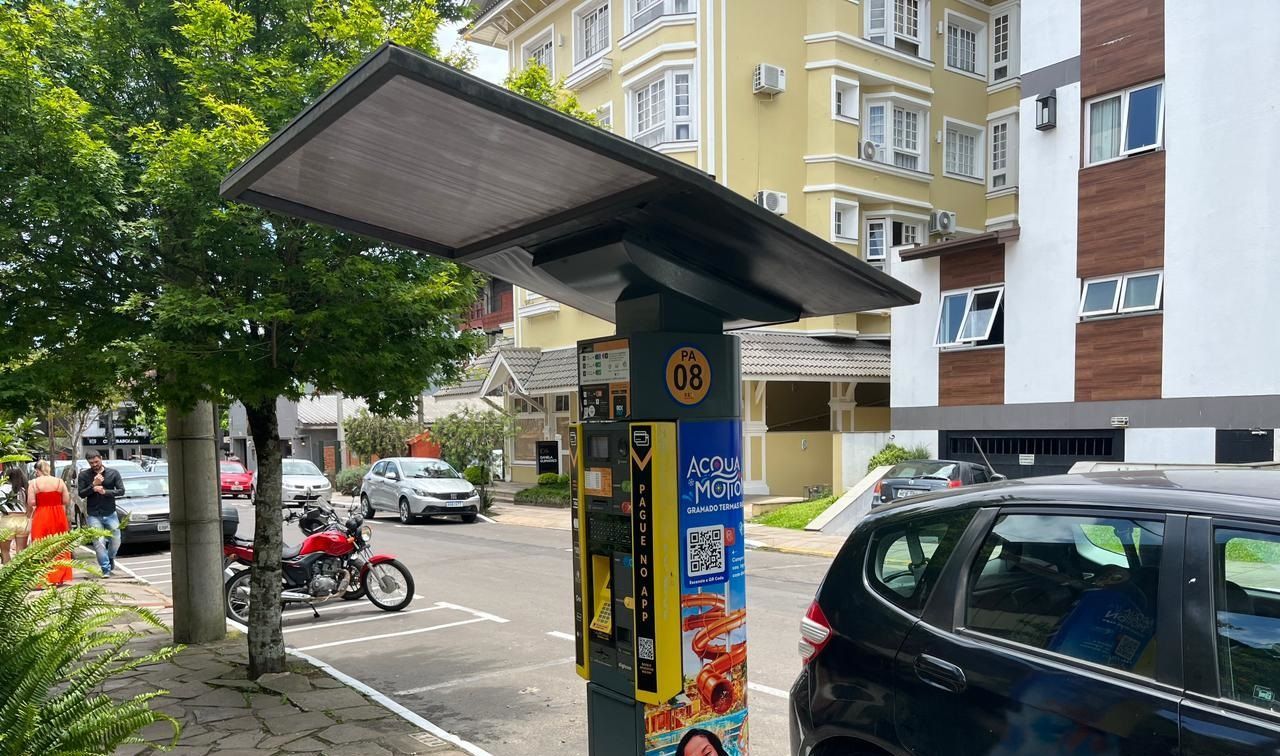 Um carro preto está estacionado em frente a um parquímetro.