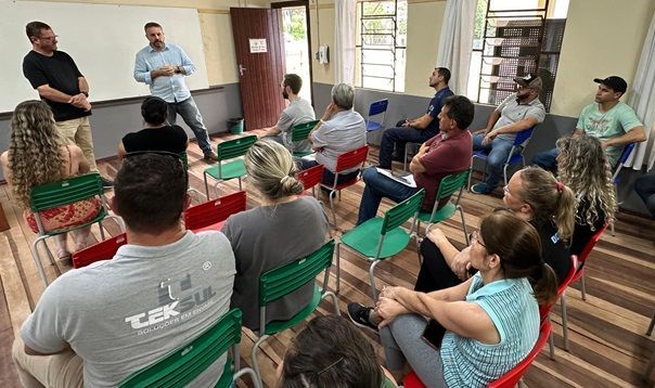 Um grupo de pessoas está sentado em círculo em uma sala.