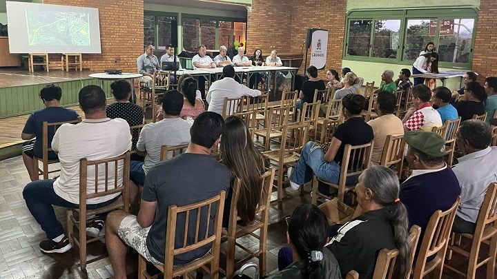 Um grupo de pessoas está sentado em cadeiras em uma sala.