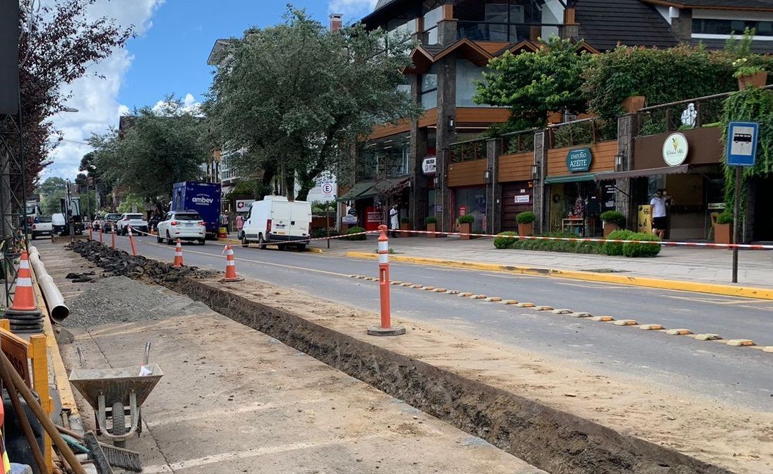 Uma rua com muita terra e um prédio ao fundo.