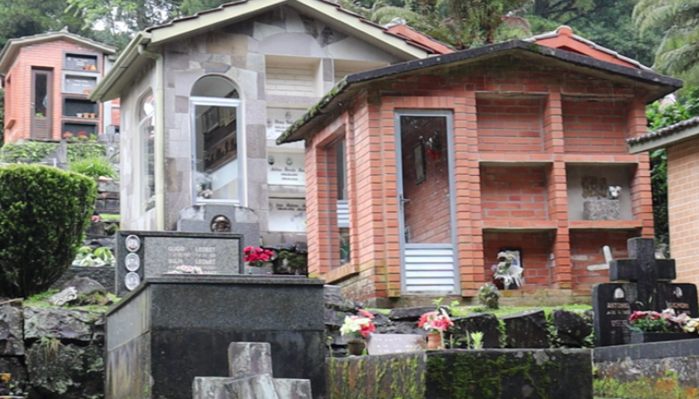Há uma pequena casa no meio de um cemitério.