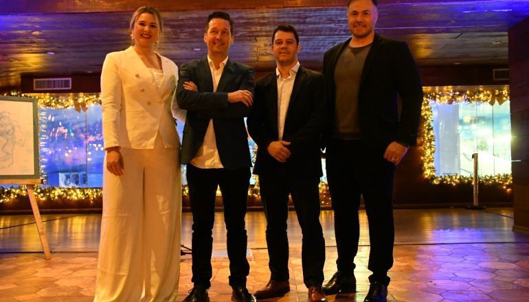 Um grupo de pessoas está lado a lado em uma sala.