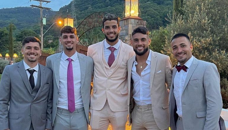 Um grupo de homens de terno e gravata posa para uma foto.