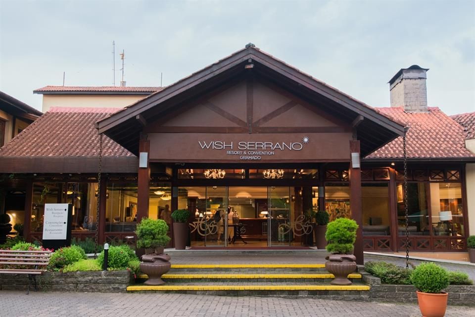 A frente de um hotel com telhado de telha vermelha