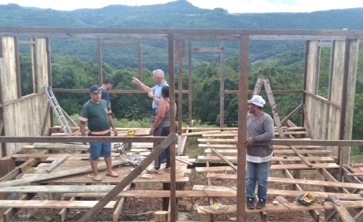 Um grupo de pessoas está trabalhando em uma estrutura de madeira.