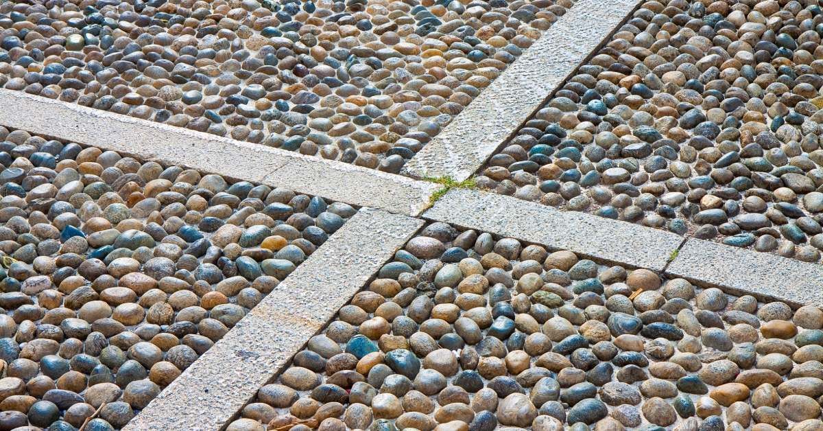 Permeable polished pebbly gravel paving covering the ground, offering an assortment of natural color