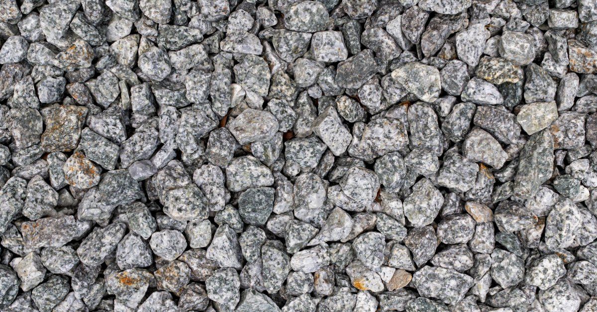 A base of grey gravel stone, up close and set up for a landscaping paving project to allow for better drainage.