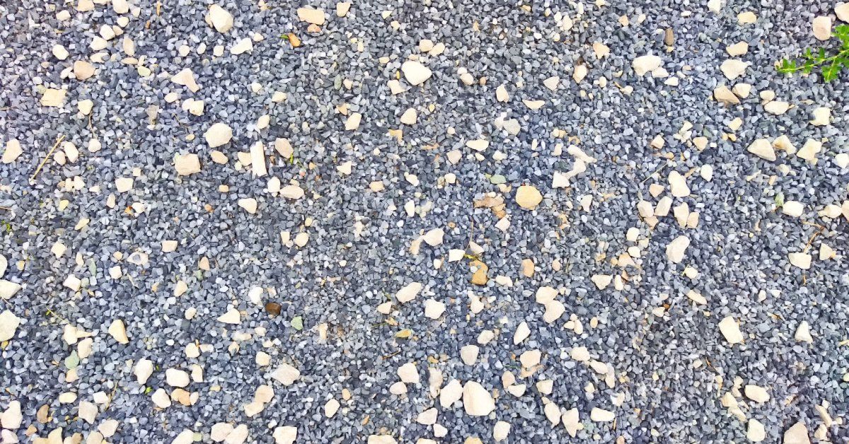 A plot of ground covered by a patch of textured gravel and small stones, creating a firm base for paving.