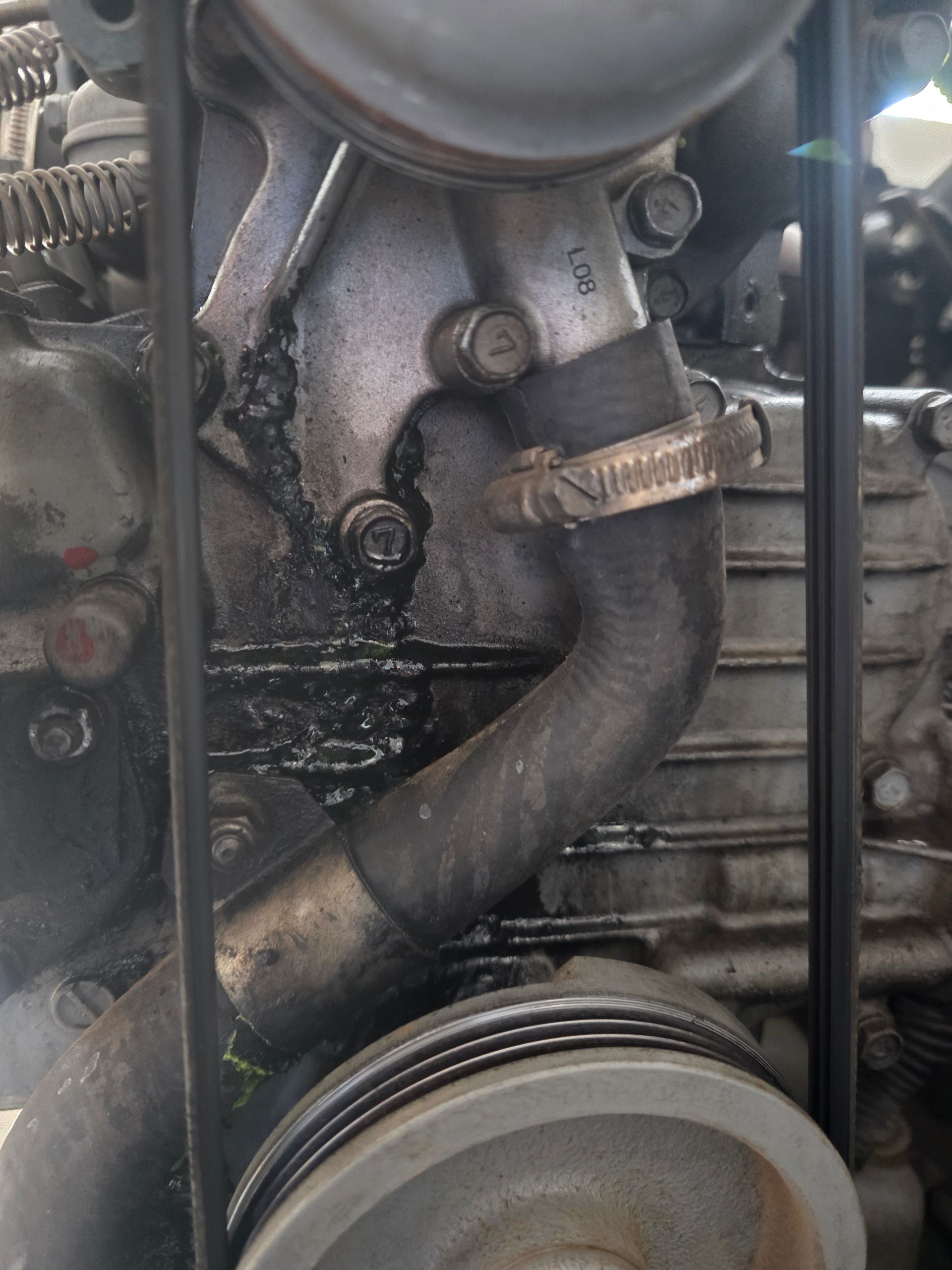Engine Block With a Curved Hose, Showing Signs of Leakage and Corrosion — BNS Refrigeration Services in Healy, QLD