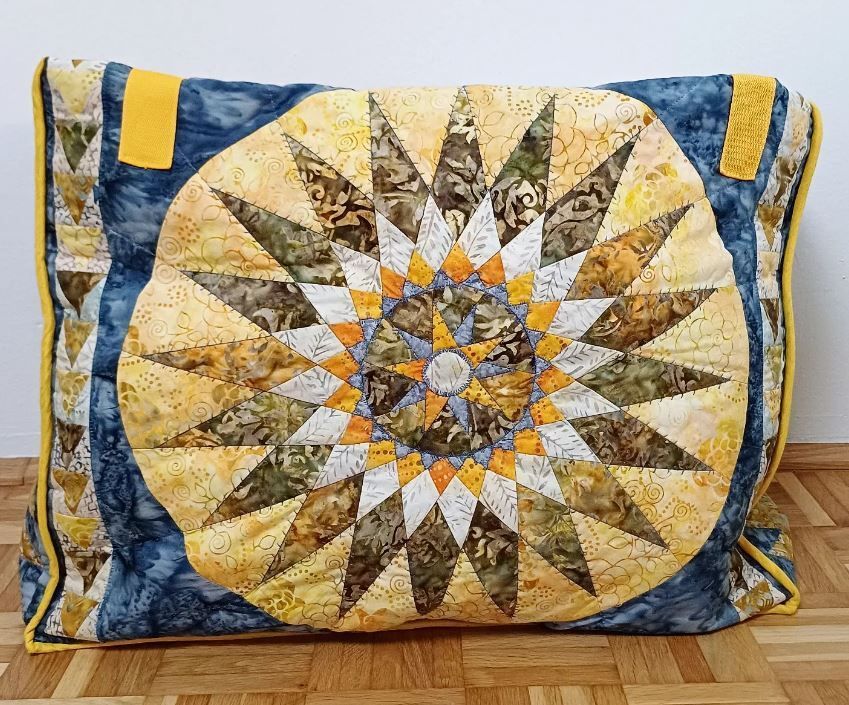 ein Kissen mit einem kreisförmigen Muster darauf sitzt auf einem Holzboden .