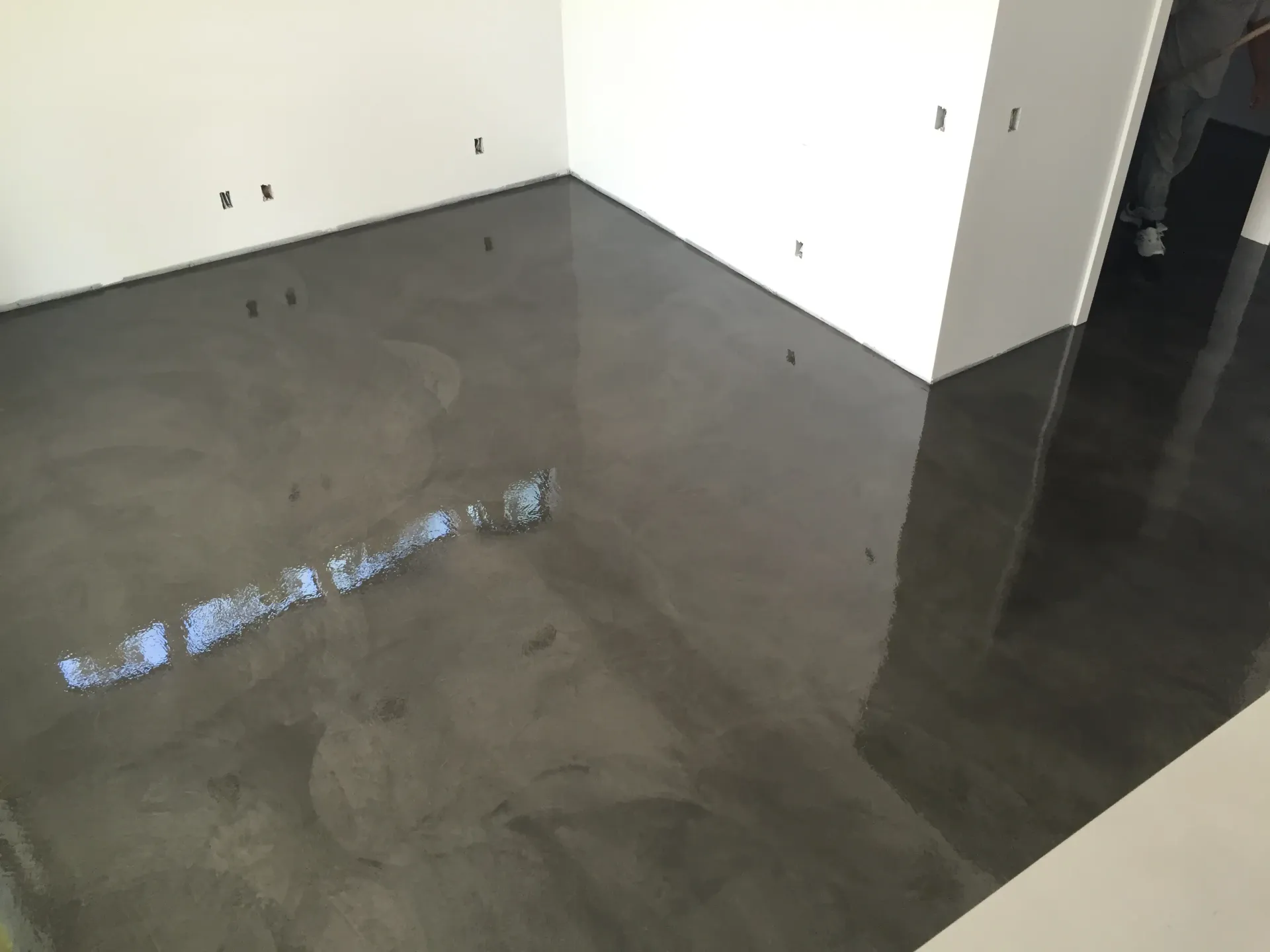 A room with a black concrete floor and white walls